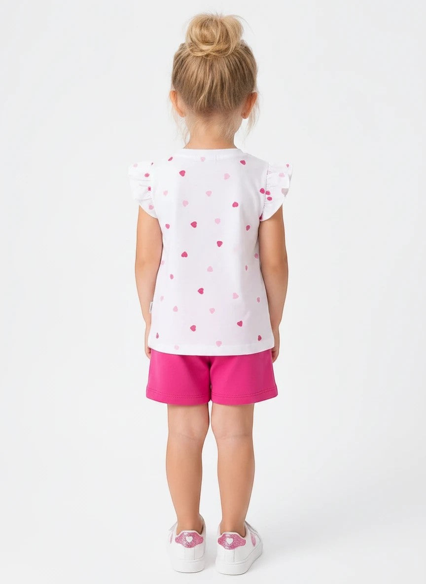 The Nile Luxuries girls white t-shirt with pink heart print and flutter sleeves paired with matching pink shorts.