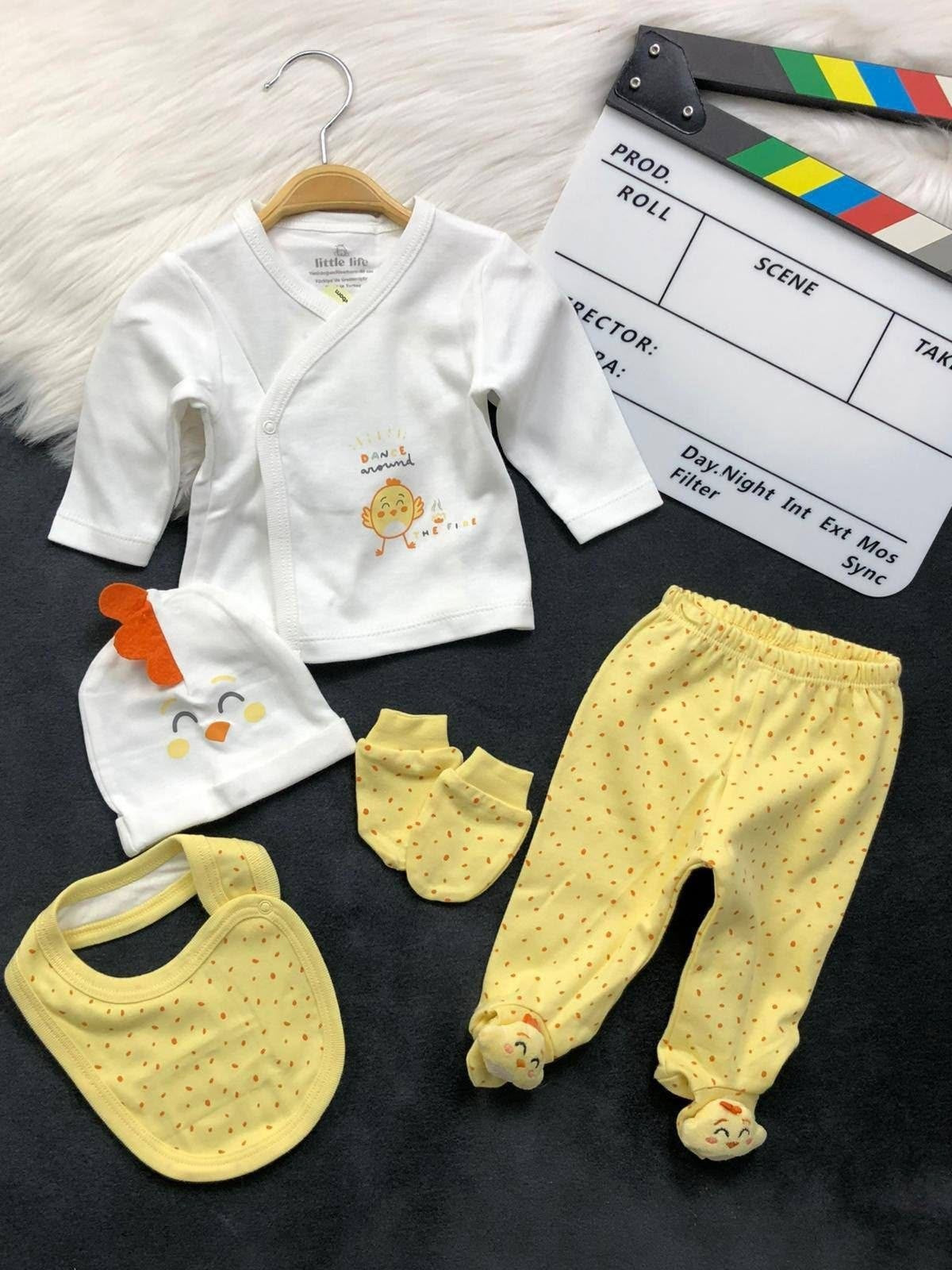 The Nile Luxuries 5-piece newborn clothing set featuring a white wrap top, yellow footed leggings, bib, hat, and mitts.