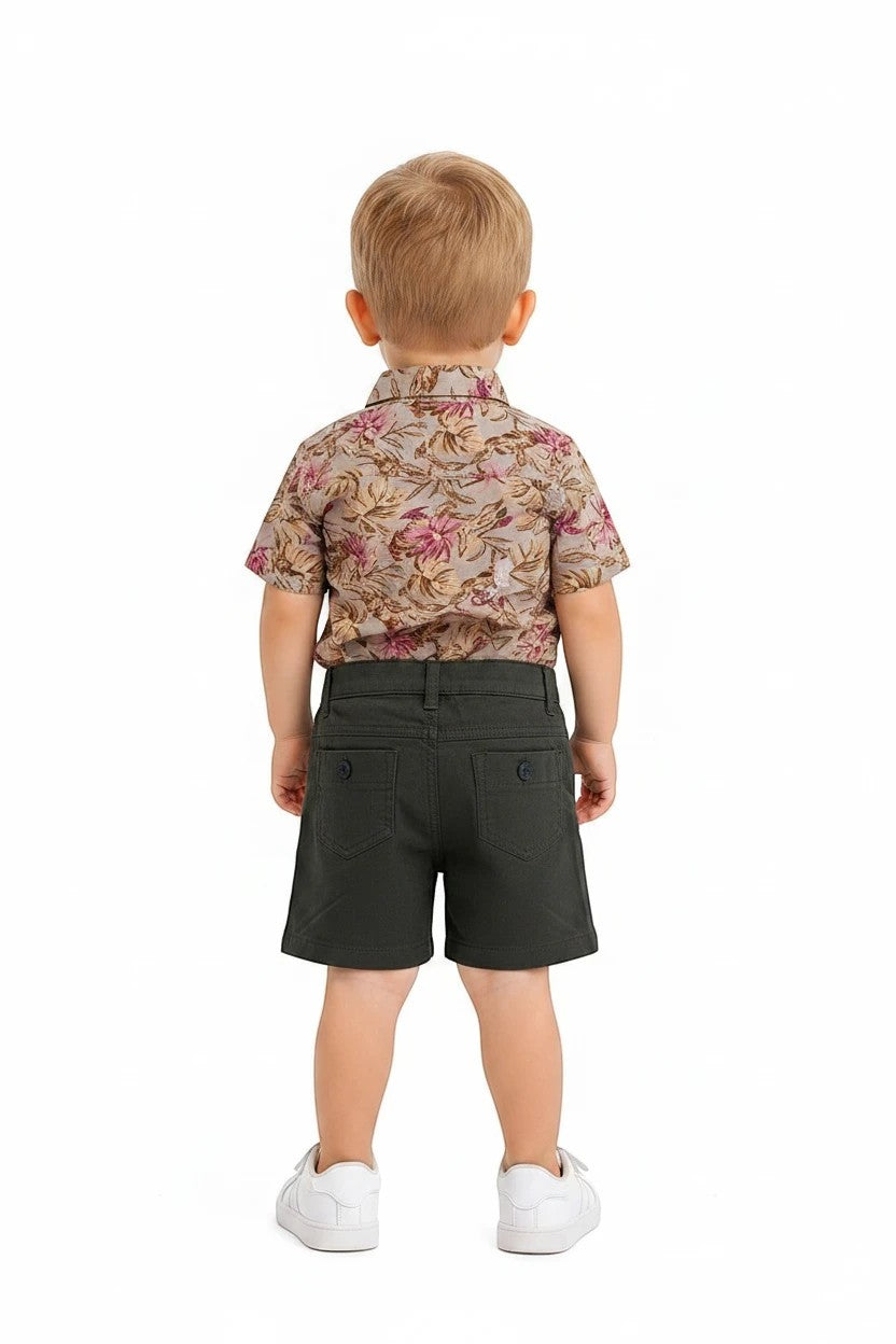 Toddler boy wearing The Nile Luxuries floral button-down shirt and olive green shorts with white sneakers