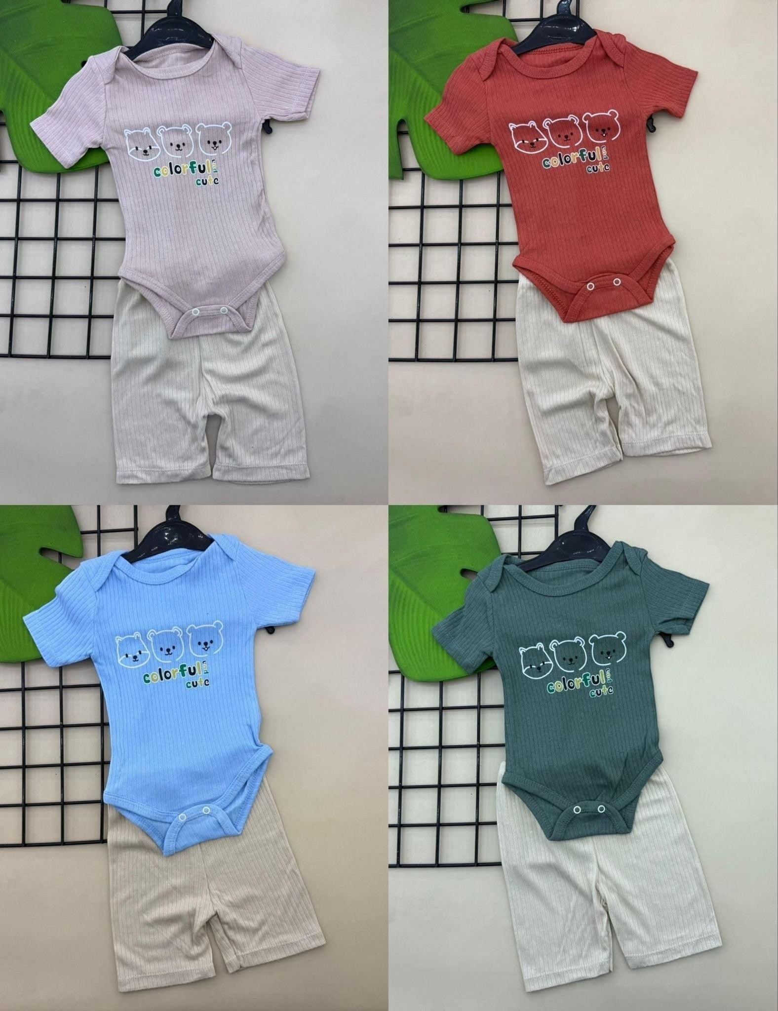 The Nile Luxuries baby bear print ribbed bodysuit and shorts set in pink, coral, blue, and green. Soft knit fabric with snap closures.