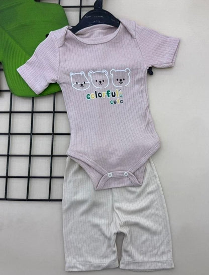 The Nile Luxuries baby pink ribbed bodysuit with three bear print and beige ribbed shorts. Short-sleeved with snap closure.