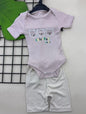 The Nile Luxuries baby pink ribbed bodysuit with three bear print and beige ribbed shorts. Short-sleeved with snap closure.
