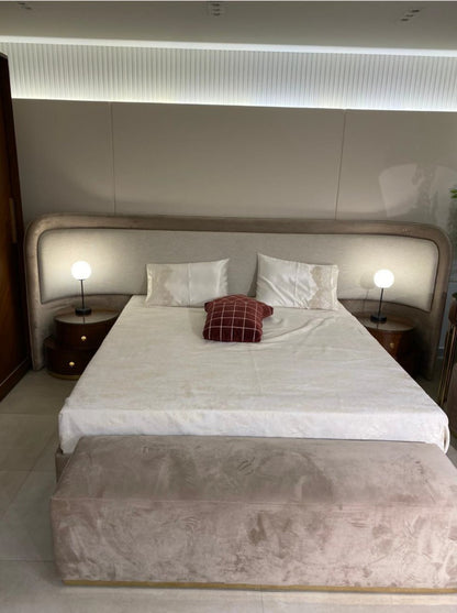 The Nile Luxuries contemporary bedroom set featuring a plush upholstered bed with a curved headboard, two bedside tables, and a velvet bench.