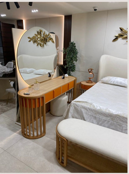 The Nile Luxuries modern bedroom set with upholstered bed, orange vanity, and rattan bench.
