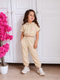 The Nile Luxuries beige cropped short-sleeve hoodie and jogger set with a daisy graphic on a young girl.