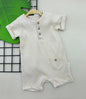 The Nile Luxuries beige ribbed cotton baby romper with short sleeves, front pocket, and three-button placket.