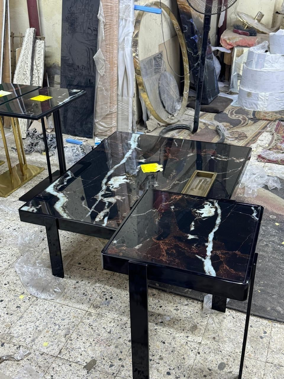The Nile Luxuries nesting accent tables with black marble-effect tops and black metal legs.