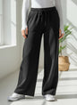 The Nile Luxuries black wide-leg lounge pants with an elastic drawstring waistband and side pockets.