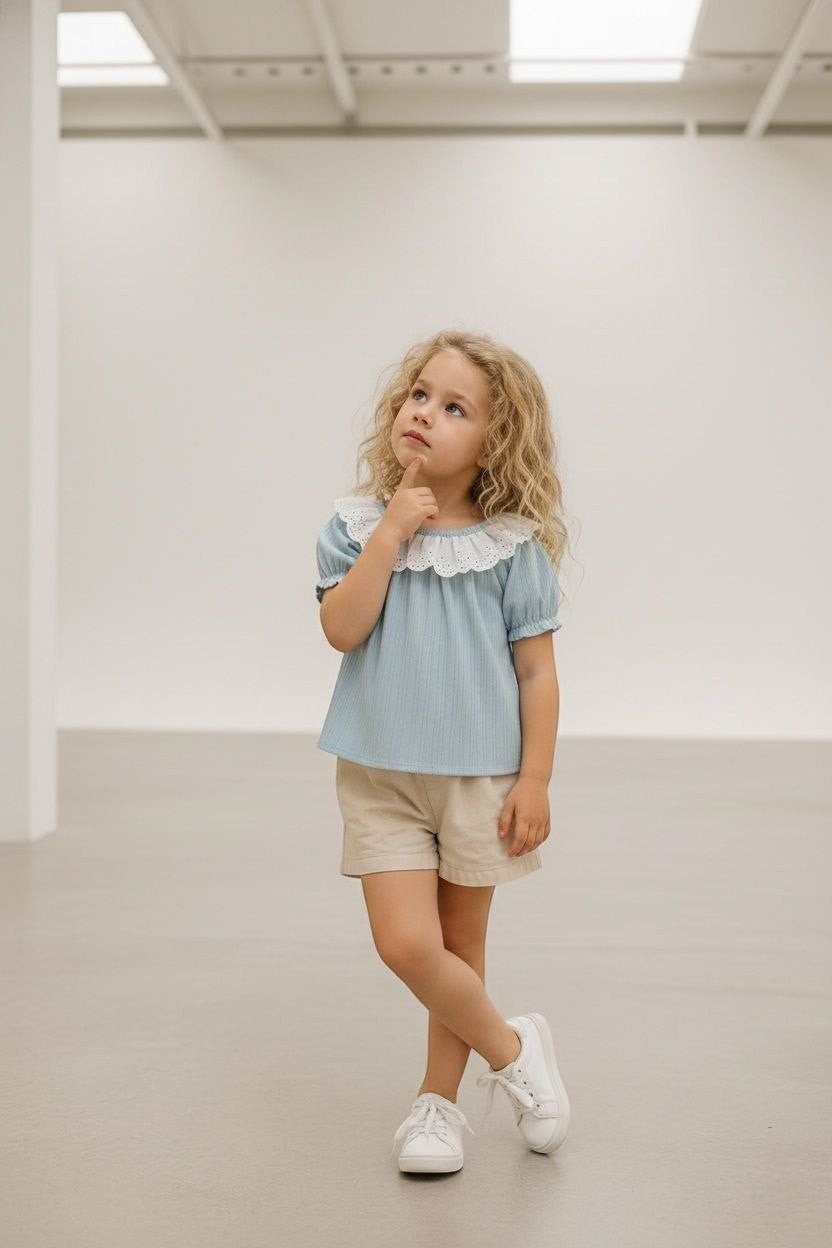 The Nile Luxuries light blue ribbed knit top with puff sleeves and white lace collar on a young girl.