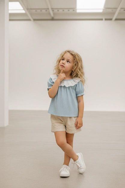 The Nile Luxuries light blue ribbed knit top with puff sleeves and white lace collar on a young girl.