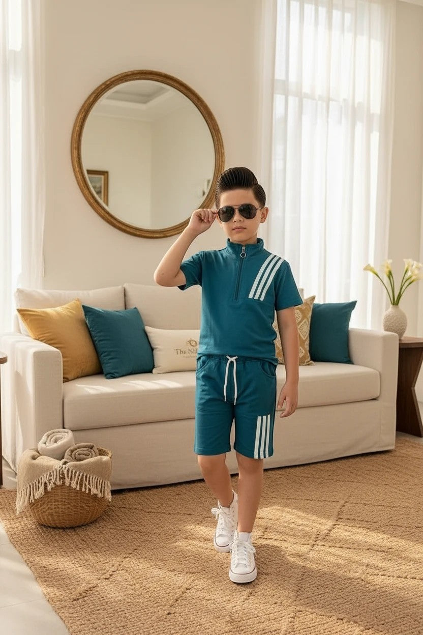 A boy wearing a teal The Nile Luxuries athletic set with a quarter-zip top and shorts featuring white triple-stripes.