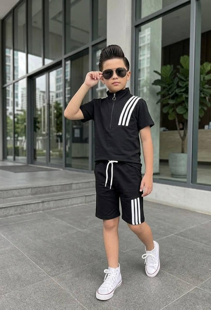 The Nile Luxuries boys black athletic set with quarter-zip top, drawstring shorts, and white triple-stripe detail.