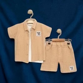 The Nile Luxuries boys' beige gauze shirt and shorts set with embroidered patch. Short-sleeved collared shirt and elastic-waist shorts.