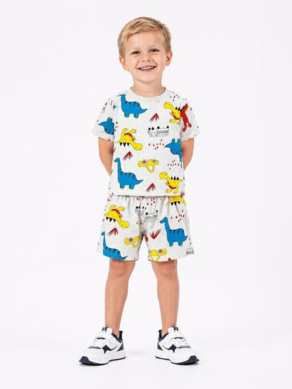 Young boy wearing The Nile Luxuries grey short-sleeve t-shirt and shorts set with colorful dinosaur print.