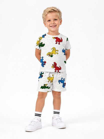 Young boy wearing The Nile Luxuries grey short sleeve t-shirt and shorts set with colorful dinosaur print.