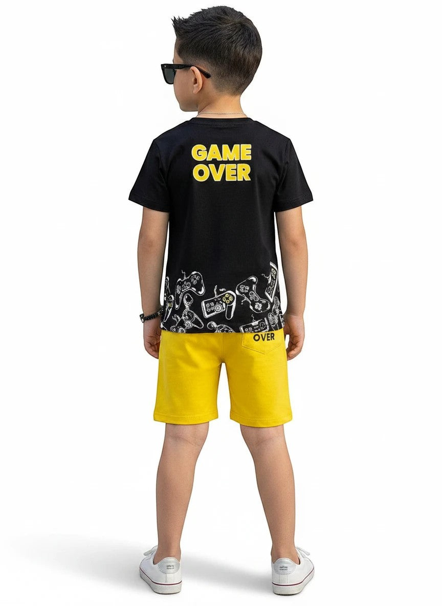 The Nile Luxuries boy wearing a black Game Over graphic t-shirt and yellow shorts with gaming controller prints.