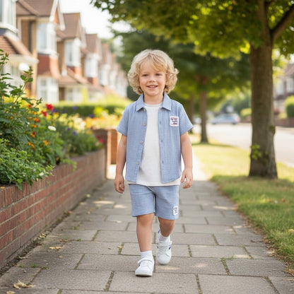 The Nile Luxuries sky blue gauze shirt and shorts set for boys, featuring a collared, short-sleeved shirt and elastic-waist shorts with embroidered patches.