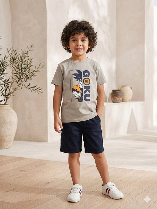 The Nile Luxuries boy wearing a grey Dragon Ball Z Goku graphic t-shirt with navy shorts and white sneakers.