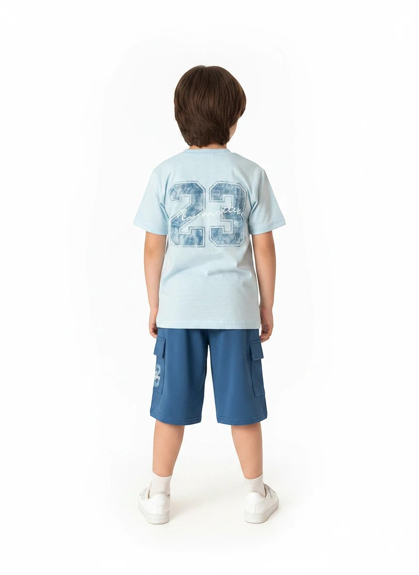 The Nile Luxuries boys light blue graphic t-shirt with 23 print and dark blue cargo shorts, back view.
