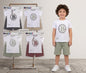 The Nile Luxuries boys white graphic t-shirt and textured green shorts outfit set worn by a young boy
