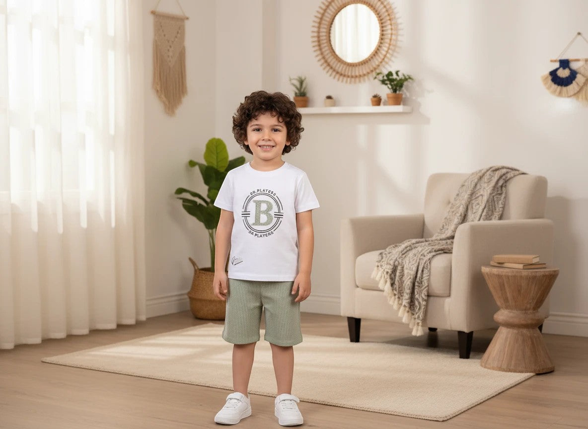 The Nile Luxuries boys white graphic t-shirt and sage green textured shorts outfit set worn by a young boy.