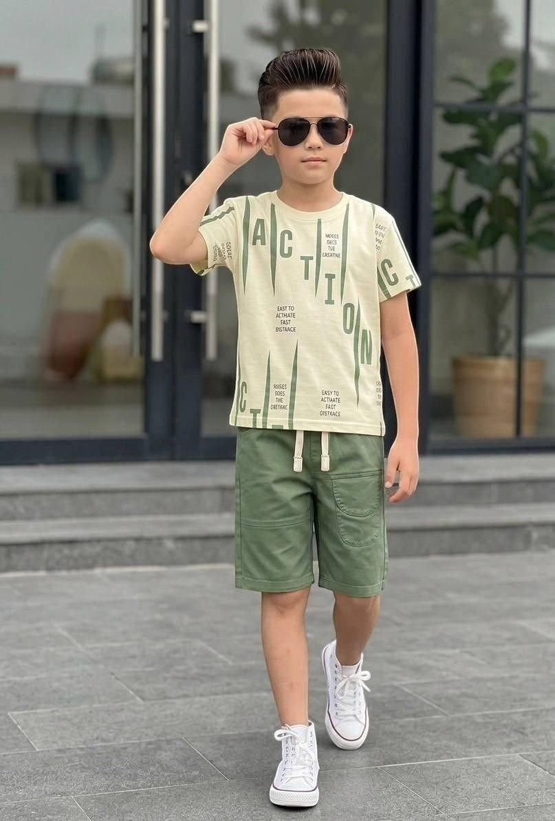 The Nile Luxuries boys' graphic t-shirt and olive green shorts set with drawstring waist and white sneakers.