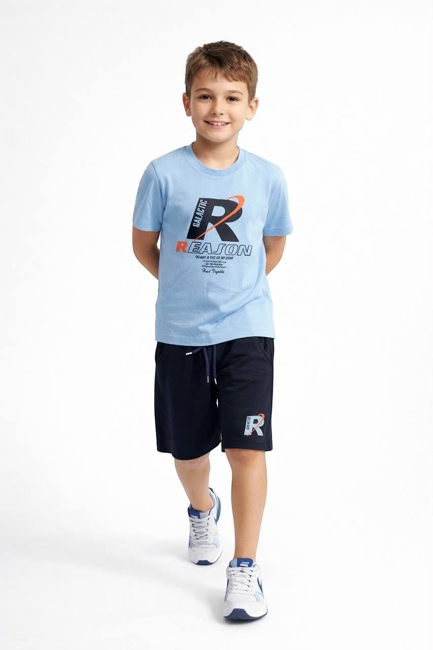 A boy wearing a The Nile Luxuries light blue graphic t-shirt and navy blue athletic shorts with a drawstring waist.