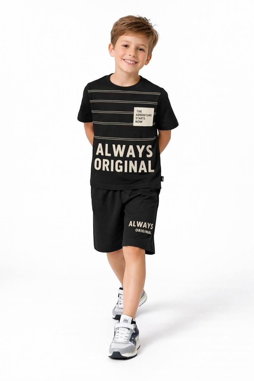 A young boy wearing a black The Nile Luxuries graphic t-shirt and matching shorts with Always Original print.