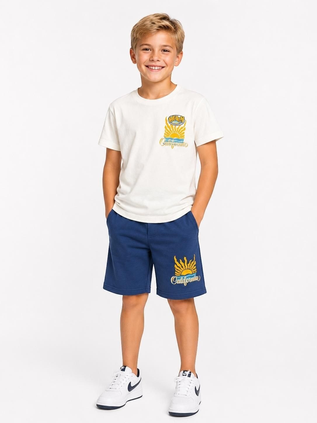 The Nile Luxuries boys' white t-shirt and blue shorts set with retro California beach graphic print.