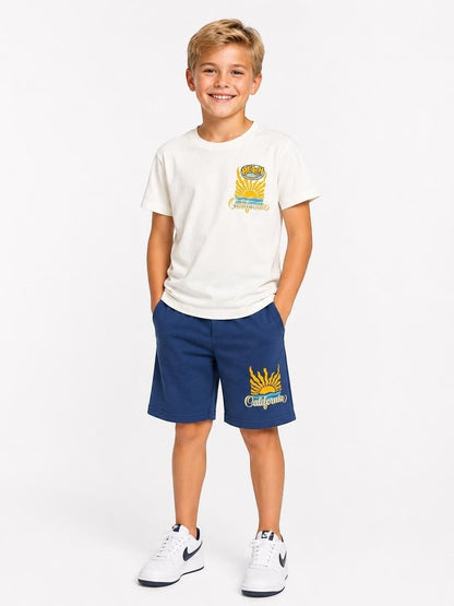The Nile Luxuries boys' white t-shirt and blue shorts set with retro California beach graphic print.
