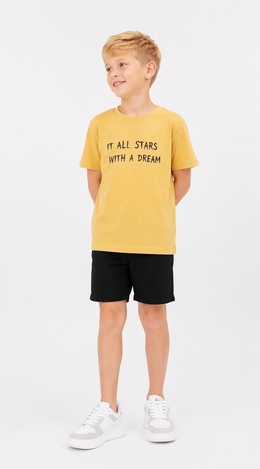 The Nile Luxuries boys mustard yellow cotton t-shirt with It All Starts With A Dream graphic print, worn by a boy.