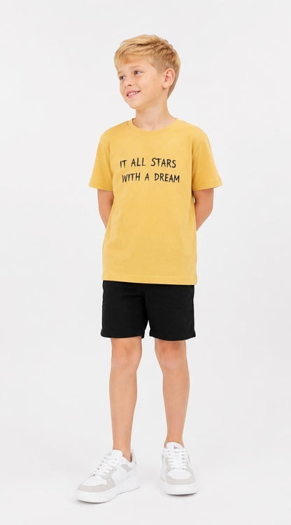 The Nile Luxuries boys mustard yellow cotton t-shirt with It All Starts With A Dream graphic print, worn by a boy.