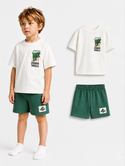 The Nile Luxuries Boys Jurassic World graphic tee and green shorts set. Off-white cotton t-shirt with dinosaur graphic. Green shorts with elastic waist.