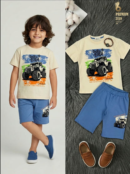 The Nile Luxuries boys cream t-shirt with monster truck graphic and blue shorts set worn by a young boy.