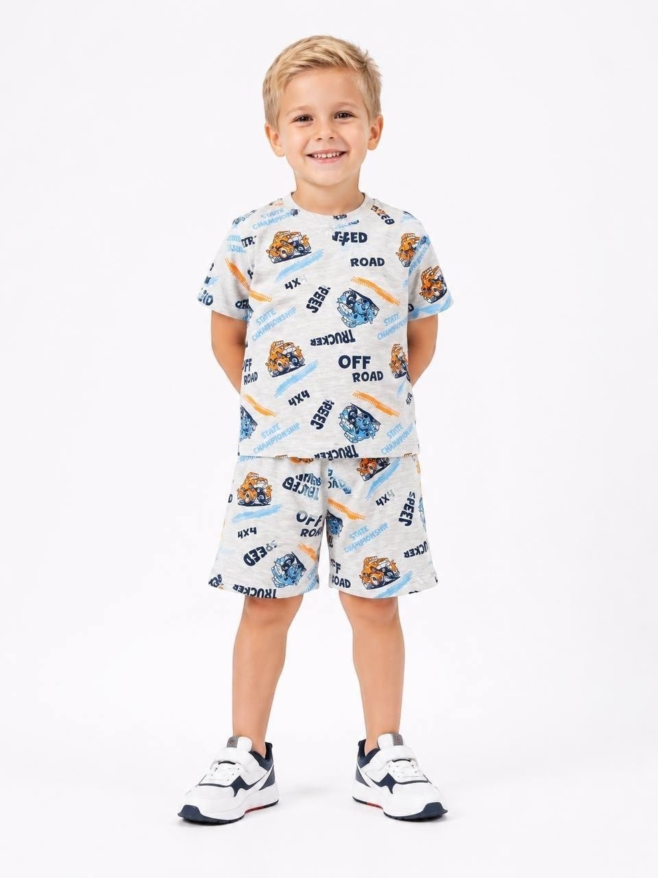 Young boy wearing a grey The Nile Luxuries short sleeve t-shirt and shorts set with off-road vehicle print.