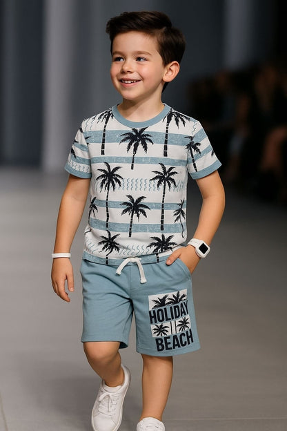 The Nile Luxuries boys' blue palm tree print t-shirt and shorts set. T-shirt has stripes and palm trees. Shorts have "Holiday Beach" graphic.