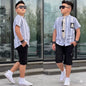 The Nile Luxuries boys summer outfit with striped short-sleeve shirt, patch detail, and black cargo shorts.
