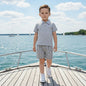 The Nile Luxuries boys' grey polo shirt and striped shorts set. Linen-blend fabric, two-button placket, elastic waistband.