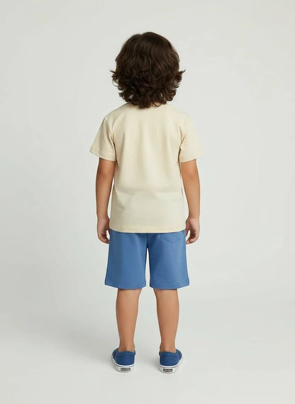 Back view of a boy wearing The Nile Luxuries cream t-shirt and blue shorts casual summer outfit set.