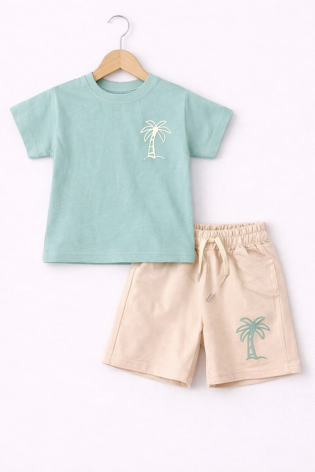 The Nile Luxuries boys sage green t-shirt and beige shorts set with palm tree embroidery and drawstring waistband.