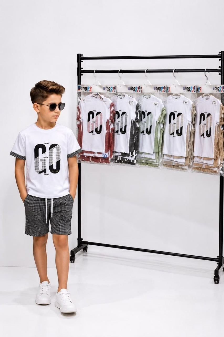 The Nile Luxuries boys summer outfit with white GO graphic t-shirt and black checkered shorts worn by a young boy