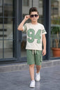 The Nile Luxuries boys' varsity t-shirt and cargo shorts set in cream and green with 94 graphic and striped sleeves.