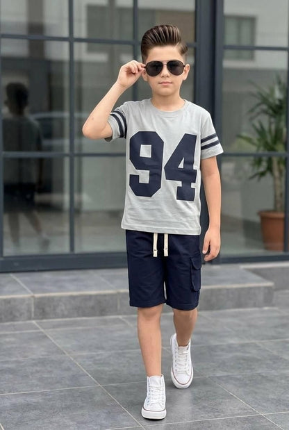 The Nile Luxuries boys' varsity t-shirt and cargo shorts set in grey and navy with a 94 graphic print.