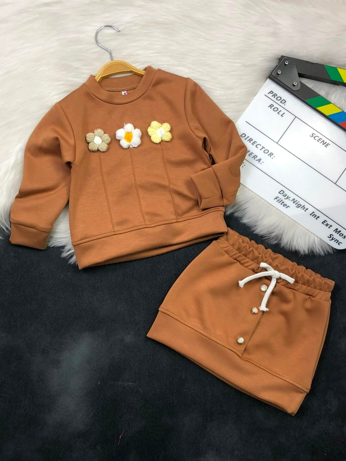 The Nile Luxuries girls brown sweatshirt and skirt set with textured floral appliques and drawstring waist detail.