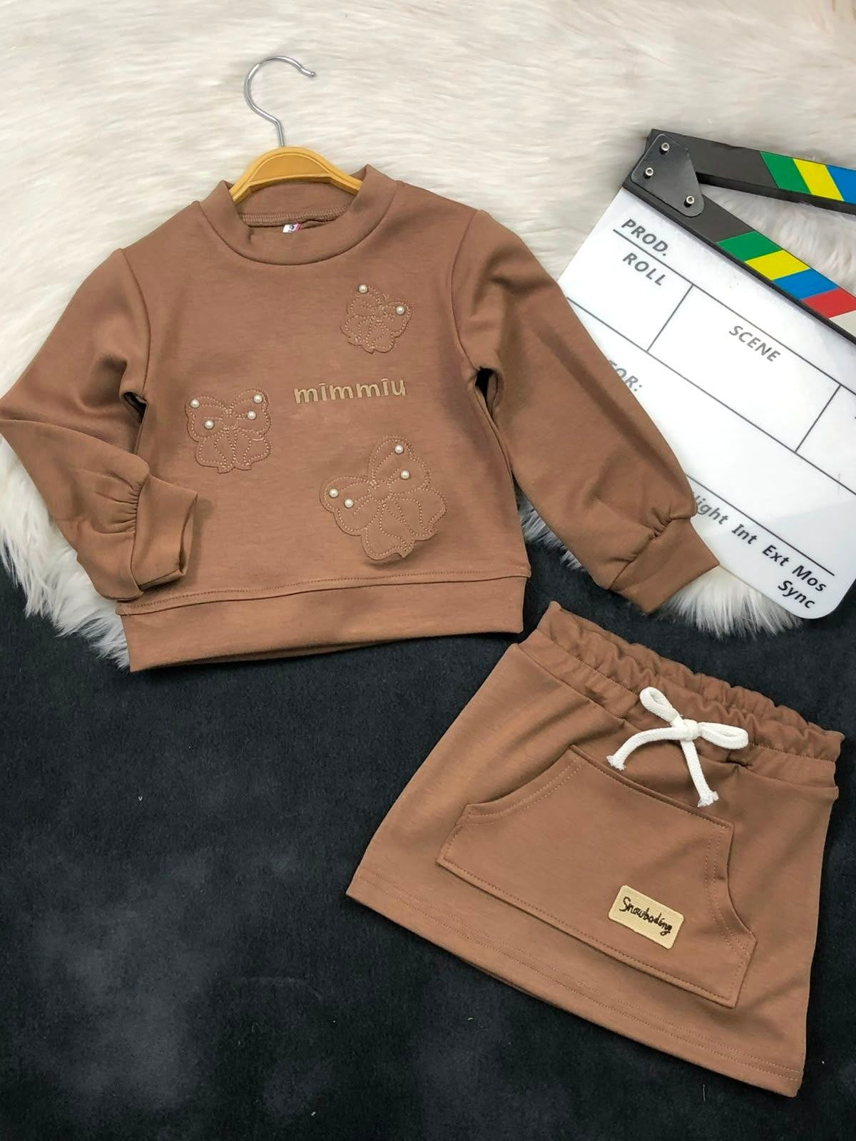 The Nile Luxuries brown long sleeve sweatshirt and skirt set with butterfly embroidery, pearl accents, and pockets.