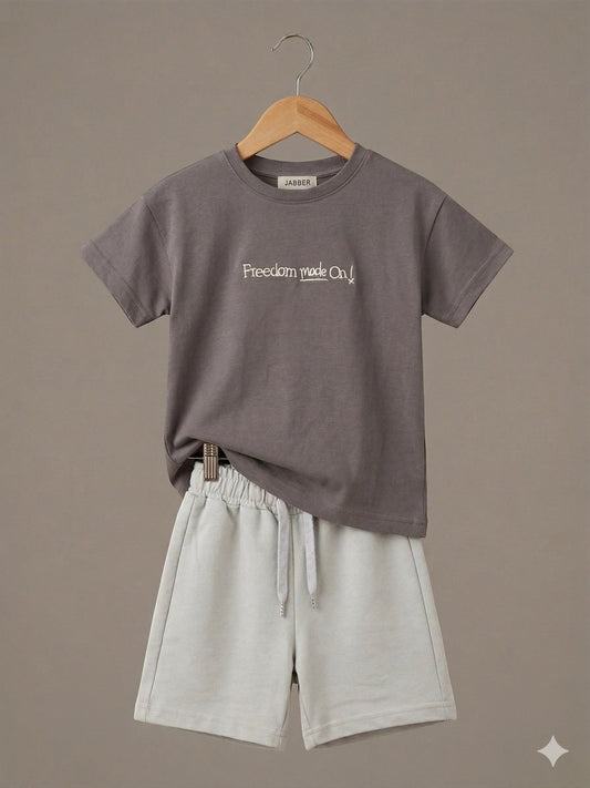 The Nile Luxuries children's charcoal t-shirt with Freedom made On! graphic and light grey drawstring shorts set.