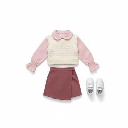 The Nile Luxuries three-piece children's set featuring a pink ruffled shirt, cream knit vest, and mauve wrap skirt.