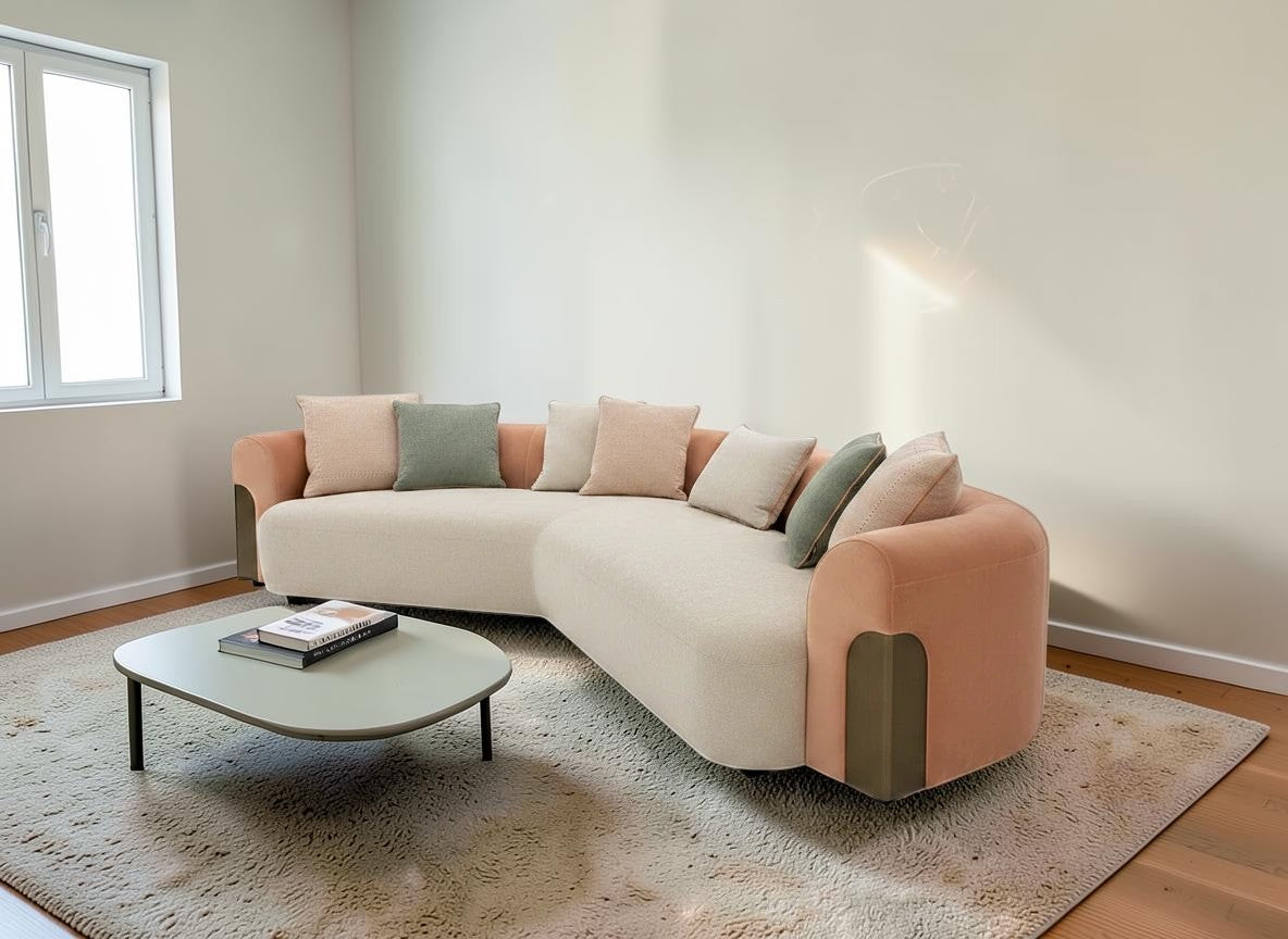 The Nile Luxuries contemporary sectional sofa in cream textured fabric with peach accents and rounded arms. Includes throw pillows.