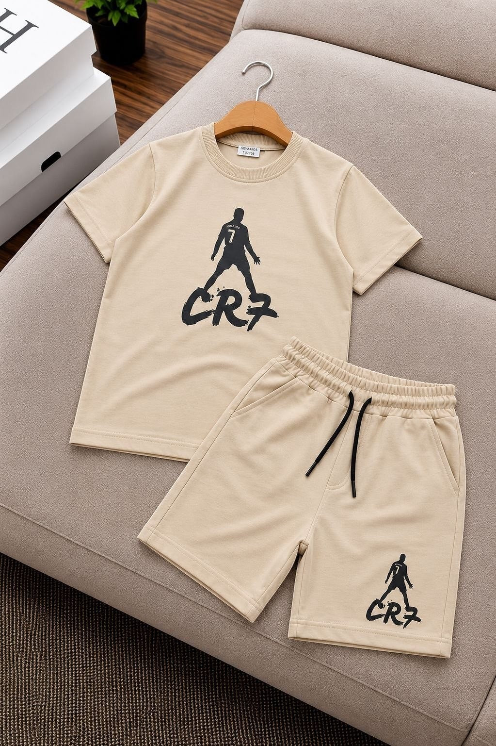 The Nile Luxuries beige athletic t-shirt and shorts set with black CR7 football graphic print and drawstring waist.
