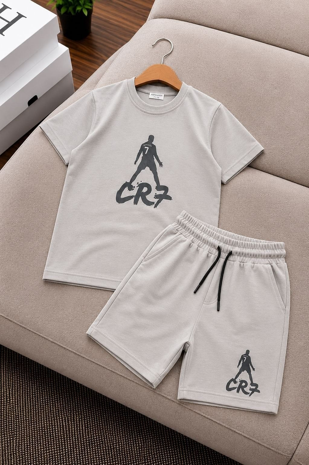 The Nile Luxuries beige CR7 graphic t-shirt and shorts set for kids with an elastic drawstring waistband.